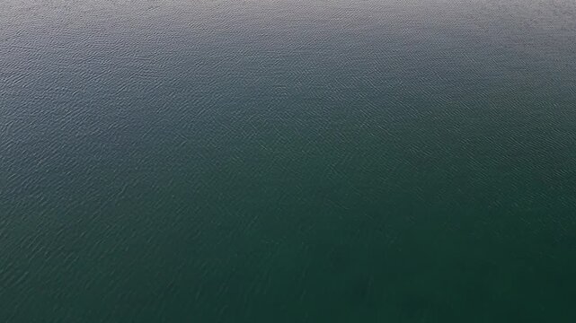 Calm water surface reflecting soft light at dusk creates a serene atmosphere in a tranquil setting