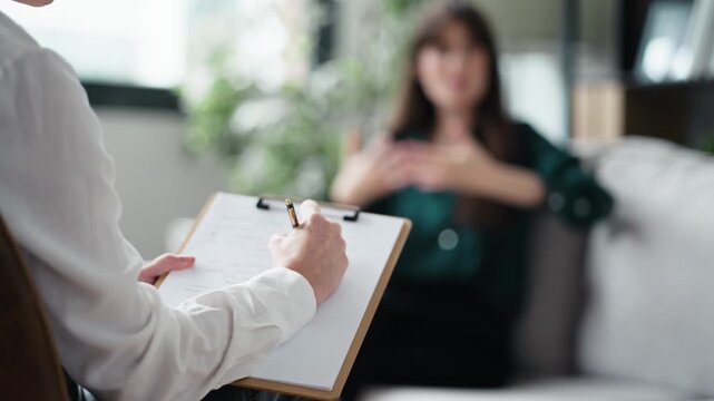 Video of beautiful woman having therapy while the psychologist takes notes, sitting on the couch in the psychology consultation
