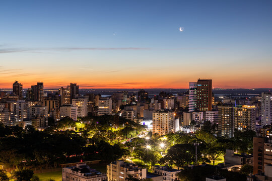 Moinhos de Vento neighborhood at sunset and first night lights and airplane lights and the moon