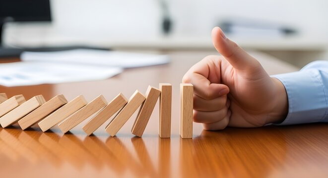 Business Professional Stopping Domino Effect with Hand Representing Risk Management and Crisis Control