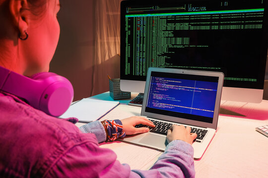 Female programmer working with laptop in office at night