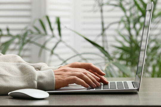 Young female programmer working with laptop in office, closeup