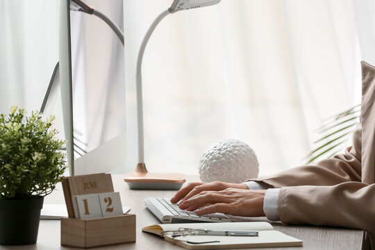 Young female programmer with computer typing on keyboard in office, closeup