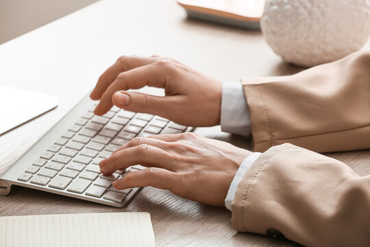 Young female programmer with computer typing on keyboard in office, closeup