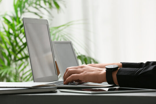 Young female programmer working with laptop in office, closeup