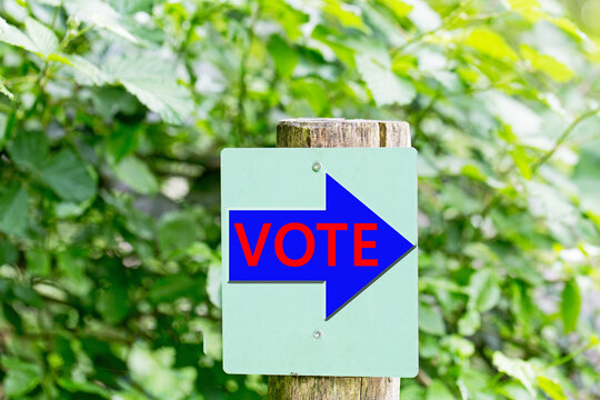 Vote sign points the way to polling location in a natural setting during election season