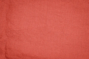Fototapeta premium Fabric in solid orange color with a textured surface laid out flat for crafting or design projects