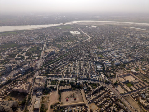 Aerial view of the dense urban sprawl, residential blocks, and busy roads with the Indus River in the background Hyderabad, Sindh, Pakistan.