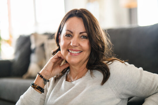 Beautiful aging. Portrait pretty mature female pensioner sit on sofa