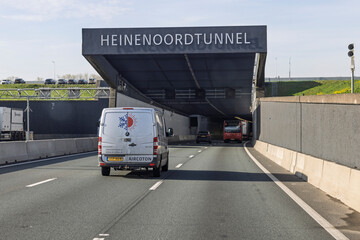 Fototapeta premium Barendrecht, Netherlands, April 15, 2026. A view of the entrance to the Heinenoordtunnel with various vehicles driving on the highway under a clear sky.