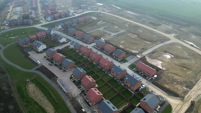Construction of new homes in a residential area in the countryside with empty lots and roads in view at Taylor Wimpey, Ripon, UK.