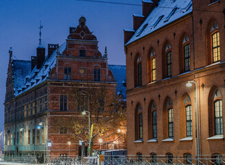 Obraz premium Historic buildings on city street in winter evening with lights.