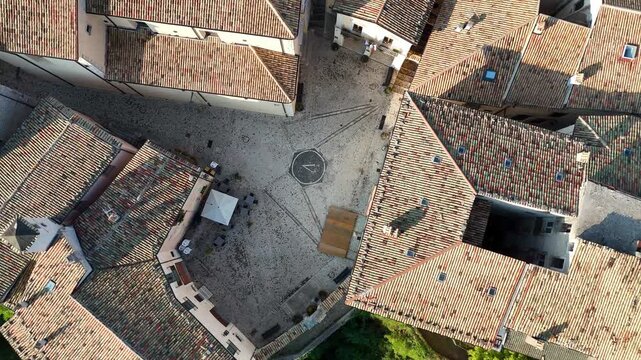Historic square unfolds under bright sunlight as rooftops of ancient buildings weave a patchwork of earthy tones and textures