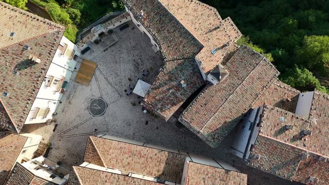 Charming hillside village with terracotta rooftops and cobblestone square in warm afternoon light