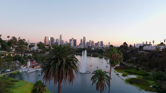 Aerial view of downtown Los Angeles skyline over Echo Park Lake with fountain at sunset