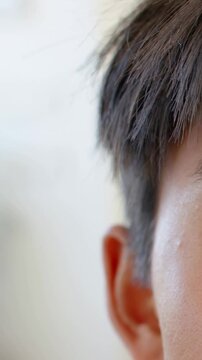 Vertical video: Recording male head breathing with hair, ear, cheek visible in interior, copy space