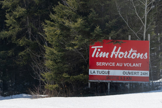 Canada, 11 April 2026 : Tim Hortons sign advertising drivethru service in snowy forest near La Tuque