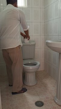 Man Placing a New Toilet Paper Roll in the Bathroom