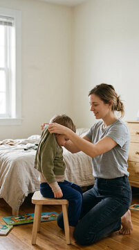 Mother helping child get dressed, daily routine, Mother's Day