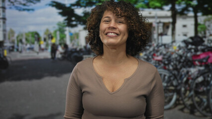 Fototapeta premium Smiling woman beckons with bare hand on bustling street lined with parked bicycles by rack; invitation.
