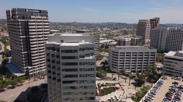 alt view of downtown Glendale CA flying back over American flag