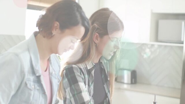 Two women preparing recipe chopping and filling blender while animated circles drifting over hands