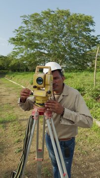 Surveyor using a total station theodolite for land measurement