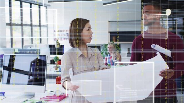 Designer unrolling blueprint while man holding sheet in studio, HUD overlay showing plan for review