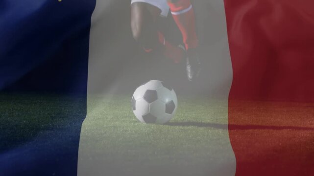 Player approaching soccer ball, contacting and driving right, sliding to ground under tricolor flag