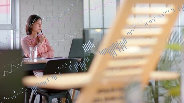 Marketer pausing typing, raising pen and causing animated charts over laptop while analyzing data