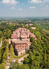 Obraz premium Italy, 10 April 2026: Aerial drone view of Dozza medieval village in Emilia Romagna, featuring the historic Rocca Sforzesca fortress, colorful murals, tiled rooftops, and scenic Italian countryside la