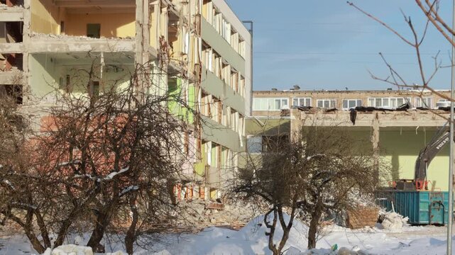 Narva, Estonia &ndash; March 2026: Excavator demolishing residential building during urban redevelopment in winter