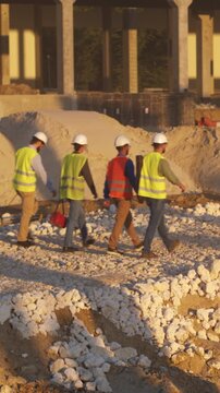 Workers inspect site, Workers in protective gear navigate through debris while supervisor conducts safety briefing