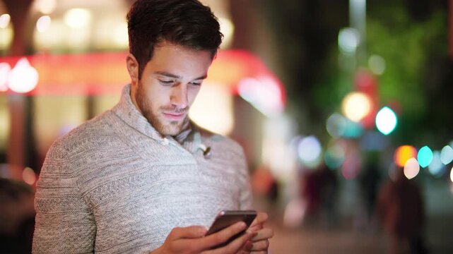 Young Man Using Smartphone At Night In City Street With Colorful Lights Representing Modern Digital Lifestyle Mobile Communication And Urban Technology Usage In Everyday Life