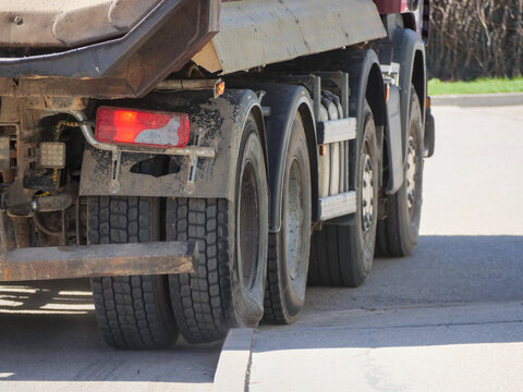 Heavy Construction Truck Rear Axle and Tyres Close Up &mdash; Industrial Vehicle Wheels Transport Infrastructure Concept