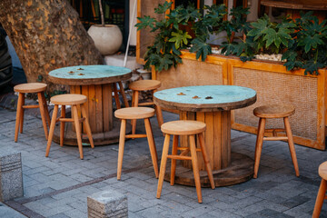 Obraz premium Charming Rustic Relax. Cozy Outdoor Seating Ambiance. Vintage Wooden Tables And Chairs Setting