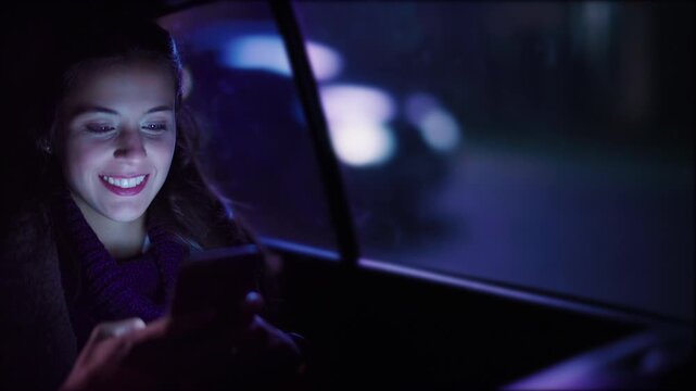 Young Woman Using Smartphone Inside A Car At Night, Illuminated By Screen Light, Representing Digital Lifestyle, Communication, And Modern Technology In Everyday Situations.