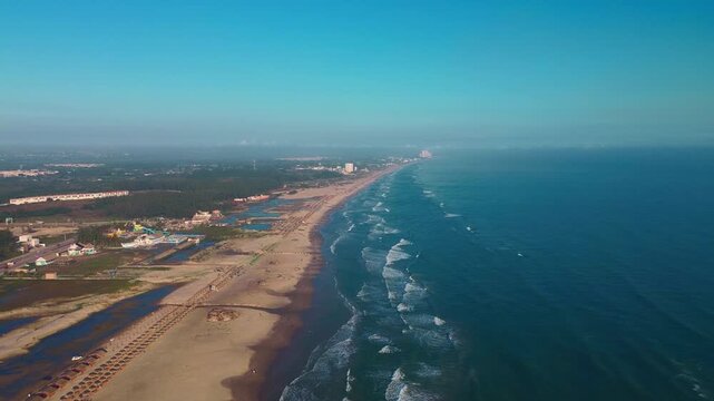 Miramar Beach Shoreline Divided by the Gulf of Mexico and Sand Featuring a Cinematic Aerial Drone Dolly In Over Calm Blue Water and Palapas in Ciudad Madero Tamaulipas Mexico