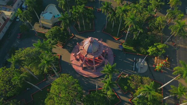 Cinematic Aerial Drone Orbit Around the Pink Octopus Kiosk at Plaza de Armas in Tampico Tamaulipas Mexico During a Quiet Sunrise with Cathedral and Government Palace View