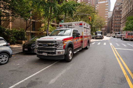 New york, usa august 15,2024. Fdny ambulance speeding through manhattan street with lights and siren, urban daytime response to emergency near city buildings