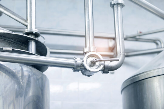 Stainless steel piping network over processing tanks in facility milk food industry