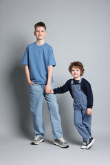 Obraz premium Portrait of cute brothers on light grey background