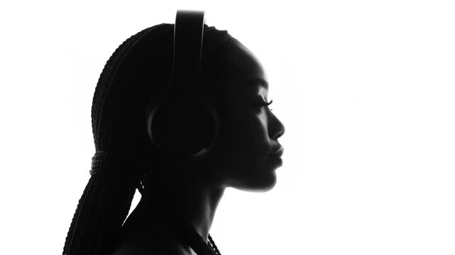 Monochrome profile view of a woman wearing headphones in silhouette.