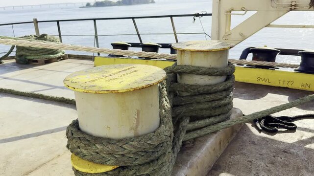 vessel moored by ropes to berth in port. mooring lines secured on bollards at the aft mooring station. 