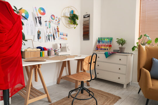 Interior of light atelier with tailor's workplace and drawers
