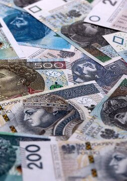 Polish zloty money bills pile on table. Poland banknotes of PLN currency close up.
