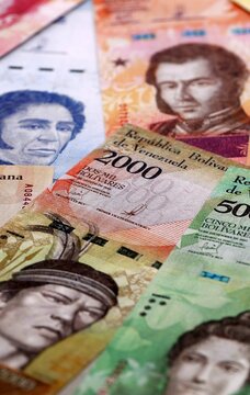 Venezuelan bolivar money bills pile on table. Venezuela banknotes of VES currency close up.