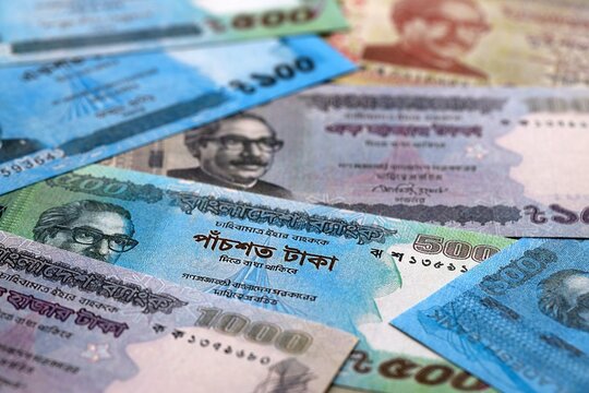 Bangladeshi taka money bills pile on table. Bangladesh banknotes of BDT currency close up.