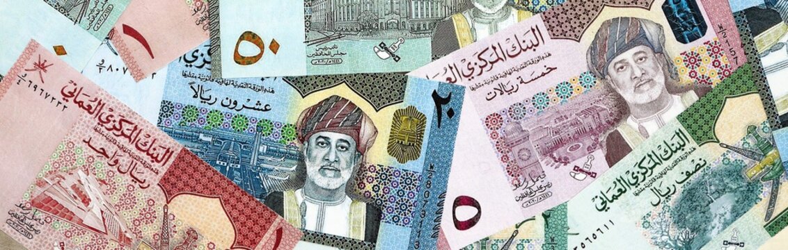 Omani rial money bills pile on table. Oman banknotes of OMR currency close up.