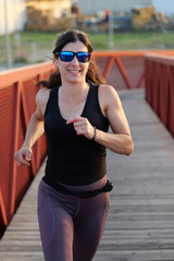 Obraz premium woman with sunglasses running on a bridge